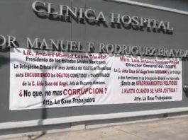 Trabajadores del ISSSTE colocan mantas ante vista de AMLO