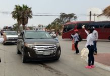 Entregan bolsas para depositar basura a visitantes de la playa
